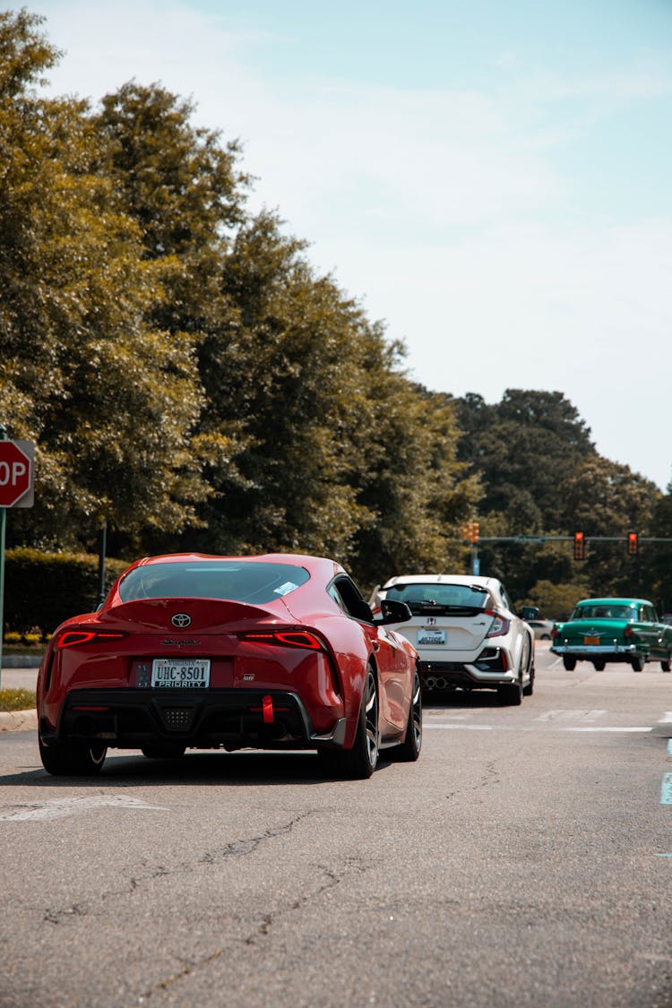 Expensive Cars Driving On Road