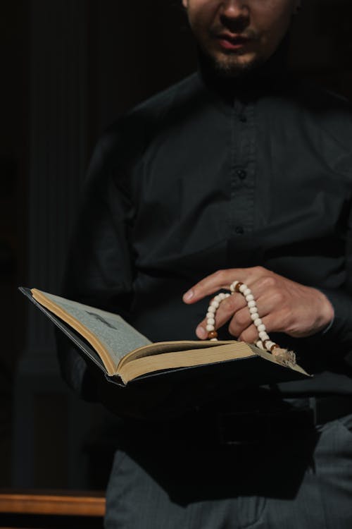 Free A Man Reading a Bible with Prayer Beads on and Stock Photo