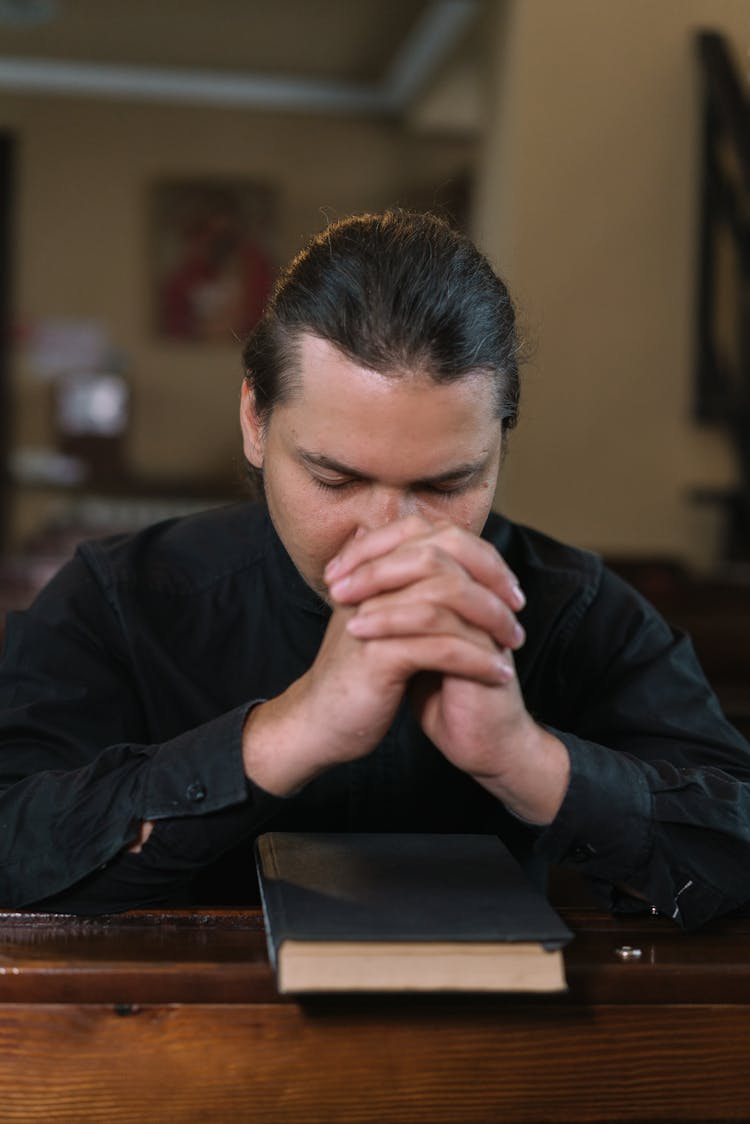 Man Kneeling On Church Pew While Praying