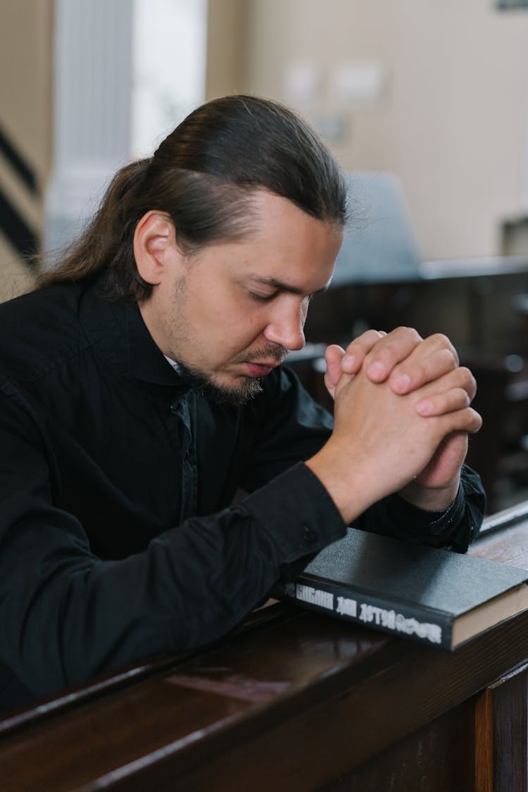 Close-up Of A Priest Praying