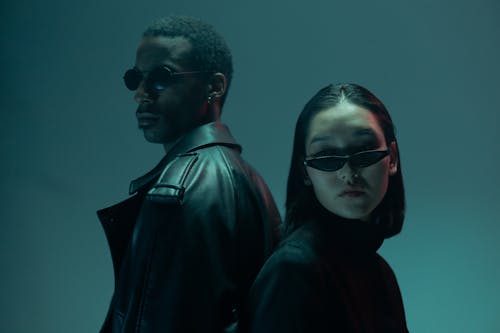 Man in Black Jacket Wearing Sunglasses Beside Woman in Black Jacket