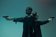 Man and Woman Back to Back and Holding Guns