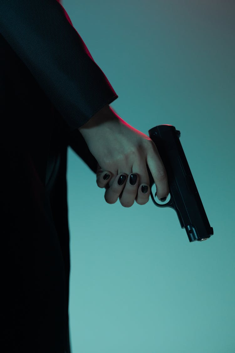 Close-Up Shot Of A Person Holding A Gun