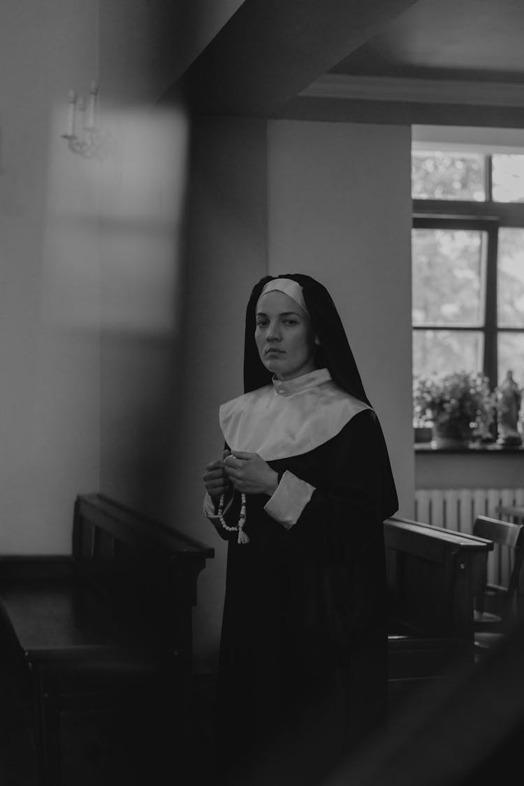 A Nun Praying Inside The Church