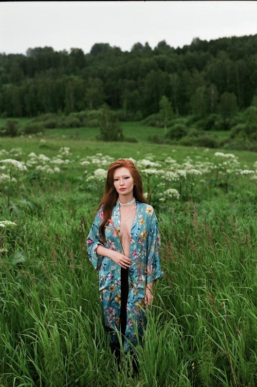 Woman Wearing Blue Silk Robe Standing on Tall Grass