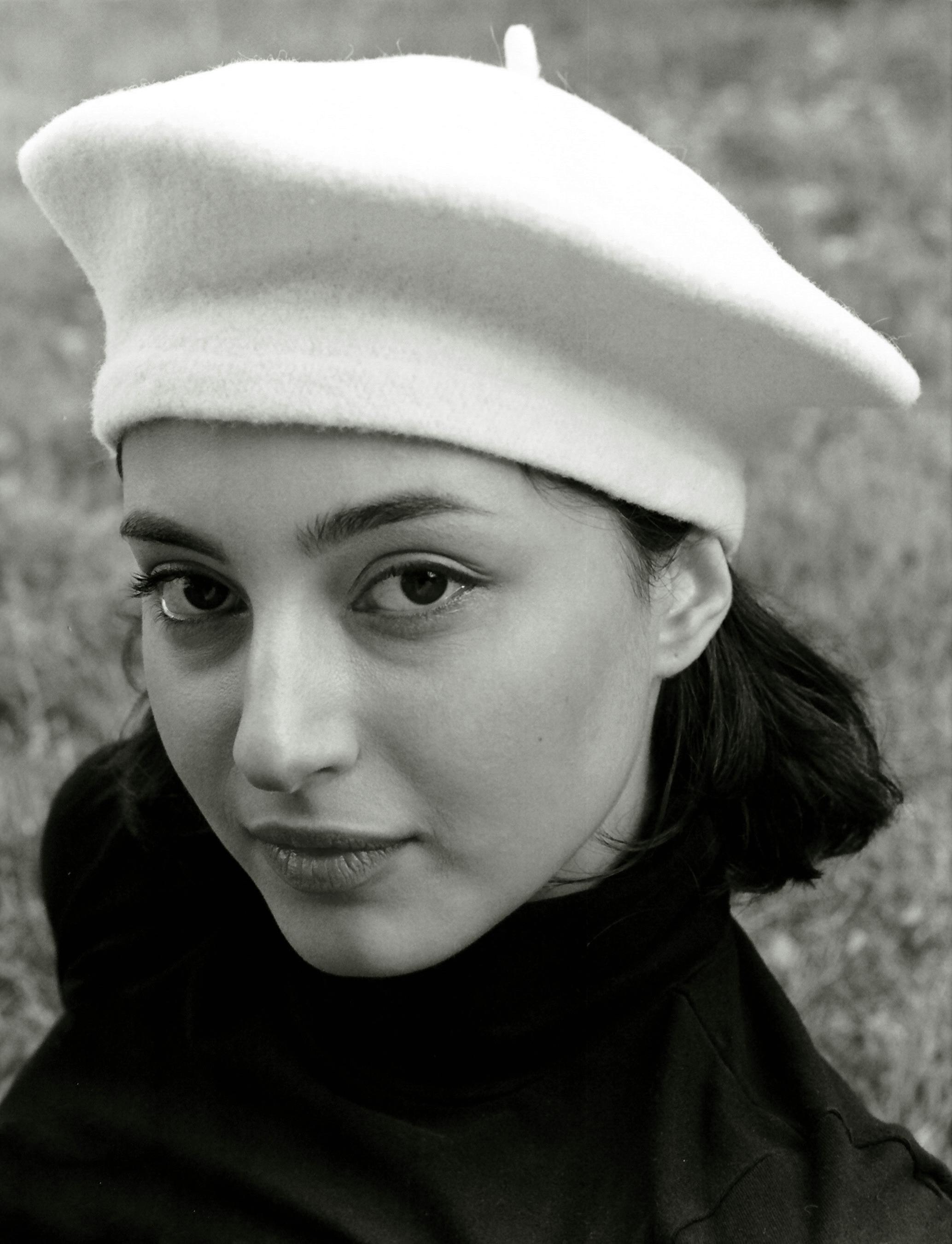 Black and white portrait of a woman wearing a beret, showing elegance.