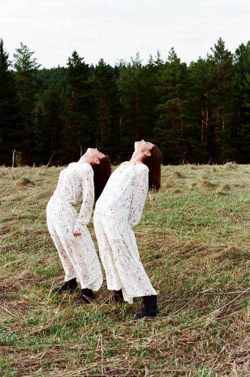 Free Women in Twinning Clothes Standing in the Grass Field Stock Photo