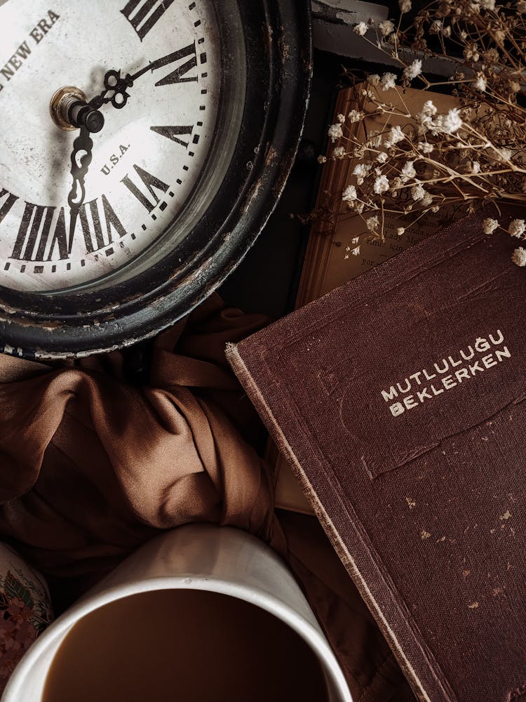 A Classic Mutlulugu Beklerken Book Beside A Antique Wall Clock