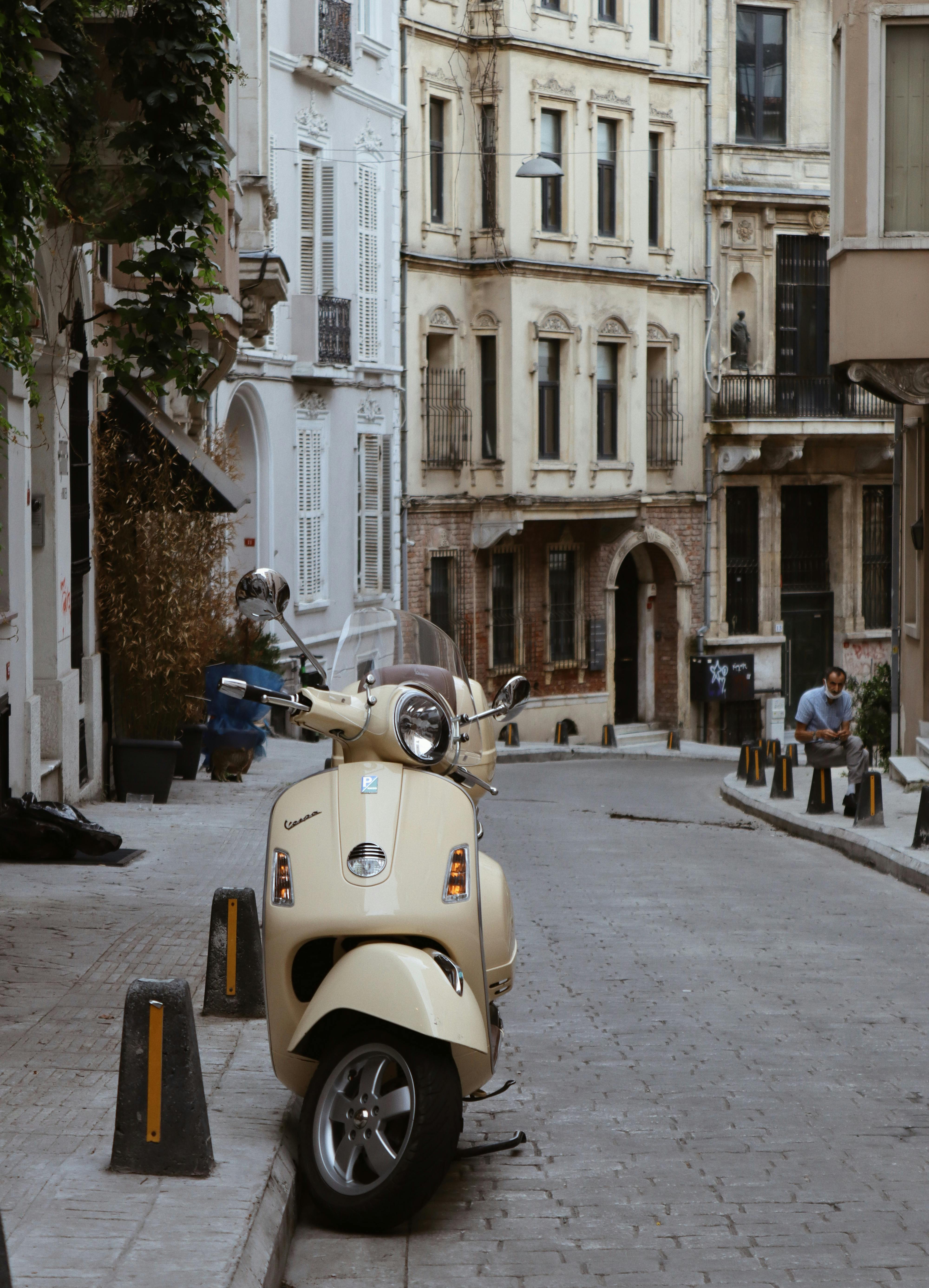 A serene European street scene featuring a parked Vespa scooter surrounded by historic architecture.