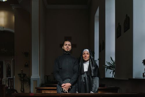 Free A priest and a nun standing together in a quiet church session. Stock Photo