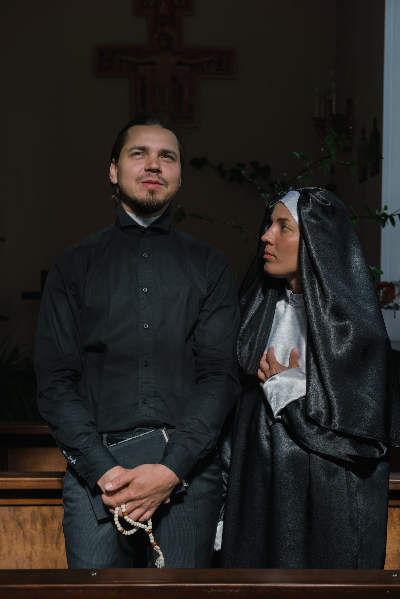 Catholic nun and priest inside a church