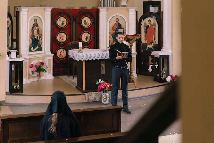 Man In Black Longsleeves Reading A Bible