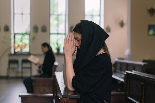 A Woman Praying while Her Hands Together