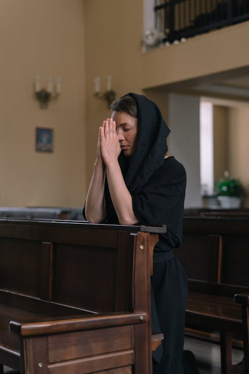 Woman Kneeling in Prayer Inside a Church