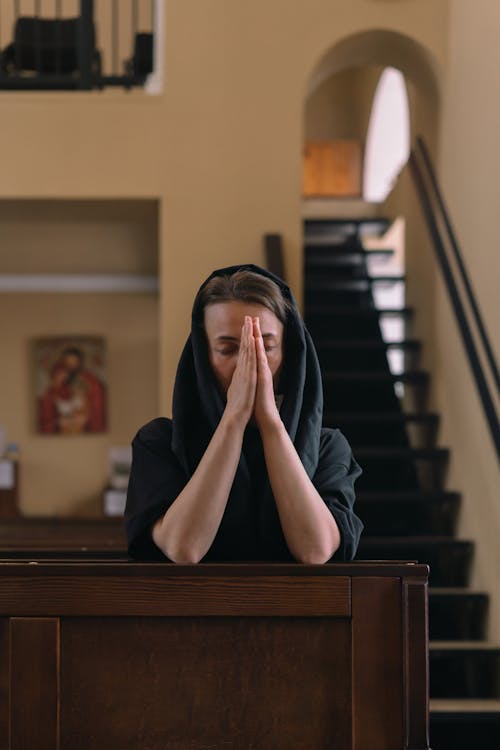 Free A Woman Praying inside a Church Stock Photo