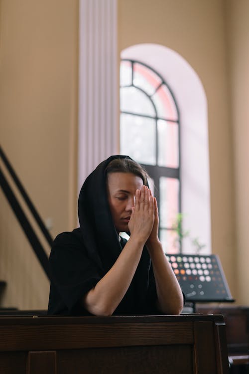 Free A Woman Praying with Her Eyes Closed and Hands Together Stock Photo