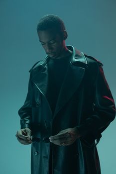 A stylish man in a leather coat adjusts his sunglasses, captured in a conceptual cyberpunk-inspired studio shoot.