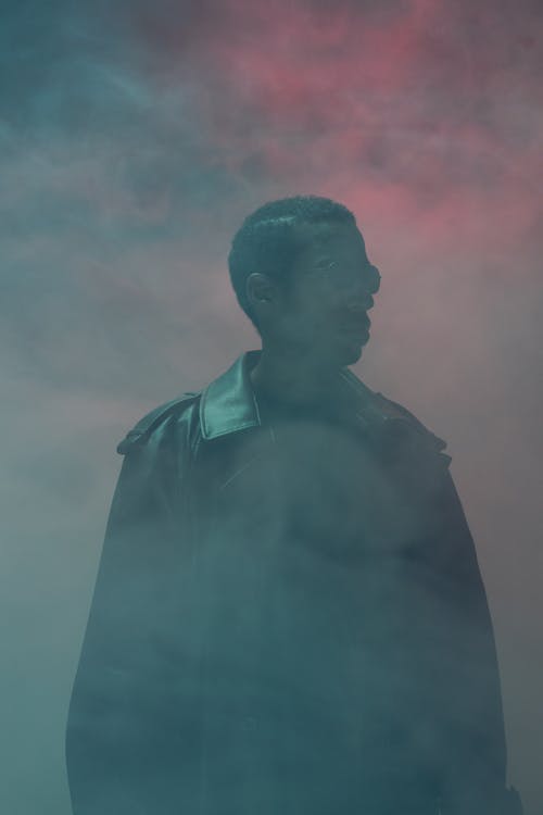 A Man in Black Coat Surrounded by Smoke