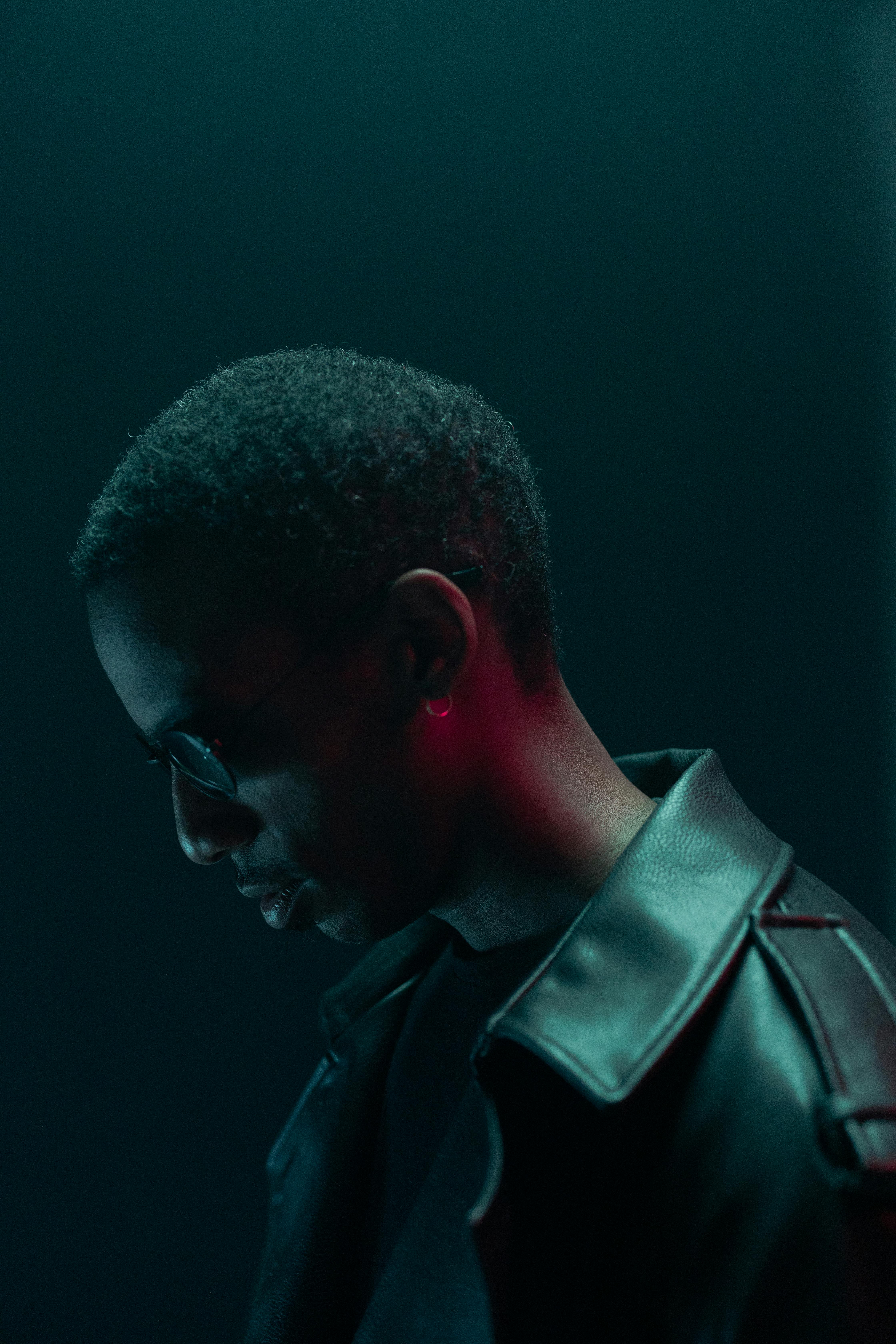 Conceptual cyberpunk portrait of a man in sunglasses and leather jacket with dramatic lighting.