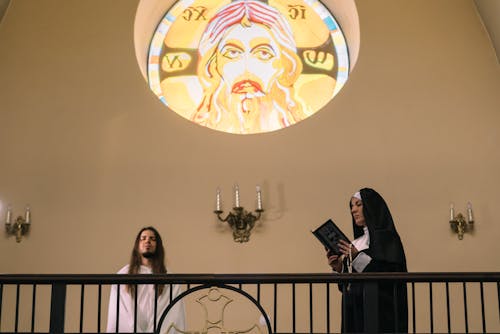 A Nun Reading the Bible while Holding a Rosary