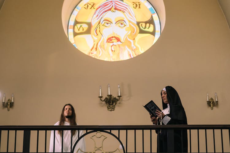 A Nun Reading The Bible While Holding A Rosary