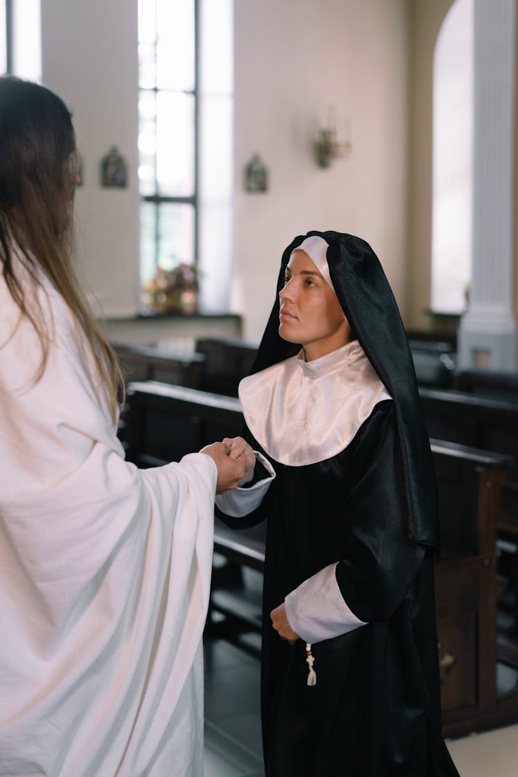 Nun Holding The Hands Of Person Wrapped In White Textile 