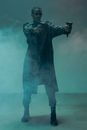 Man in Black Trench Coat Holding Two Handguns