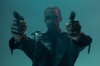 A Man in in Leather Coat Holding Handguns