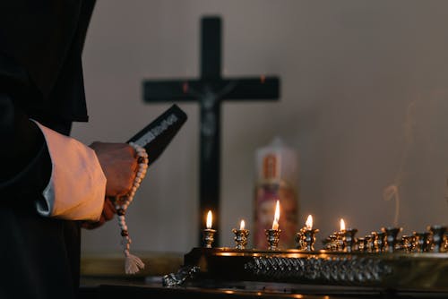 Free Person Holding Holy Book and Prayer Beads Stock Photo