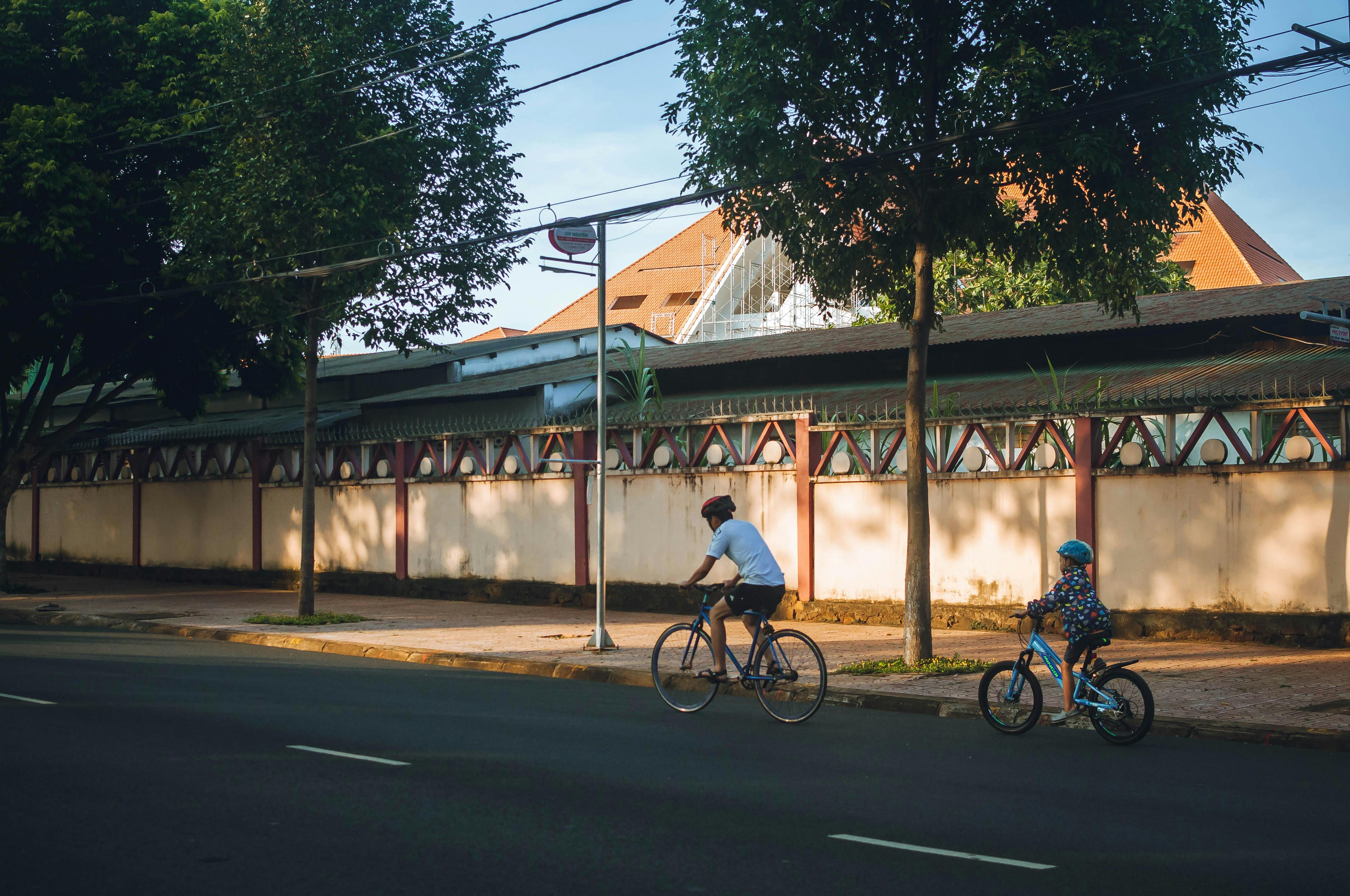 Free A Man Riding a Bike with His Child at the Back Stock Photo