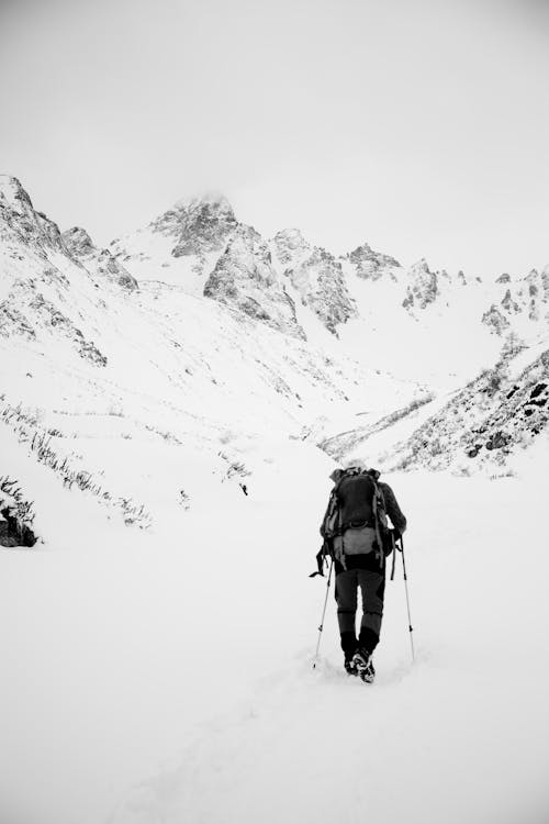 A Back View of a Person Hiking on a Snow Covered Mountain