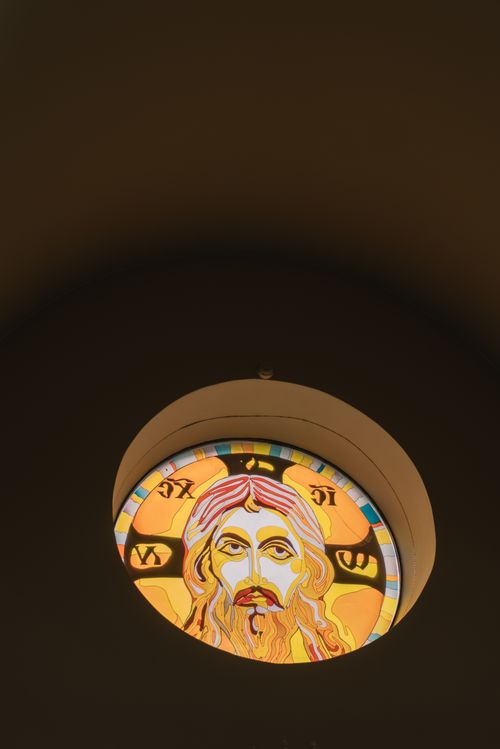 Free A circular stained glass window depicting Jesus Christ in vibrant colors. Stock Photo