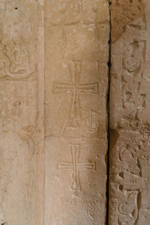 Free Close-up of carved stone cross designs on an ancient wall showcasing religious symbolism and patterns. Stock Photo