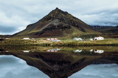 Green and Brown Mountain Beside Lake