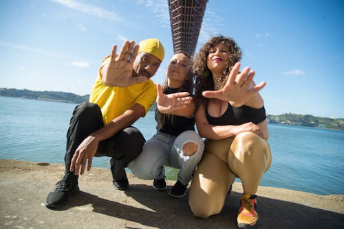 A Group of People Sitting on the Shore Extending their Arms in Front