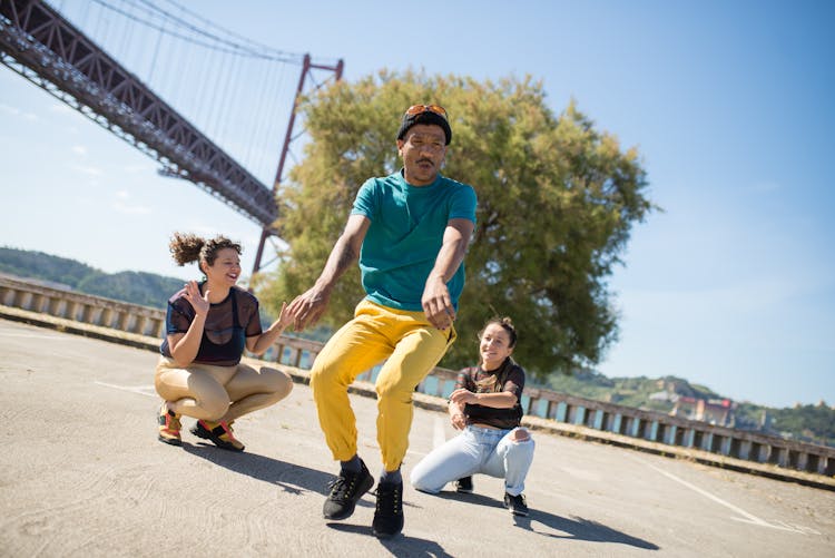 Man In Blue Shirt And Yellow Pants Dancing On The Road