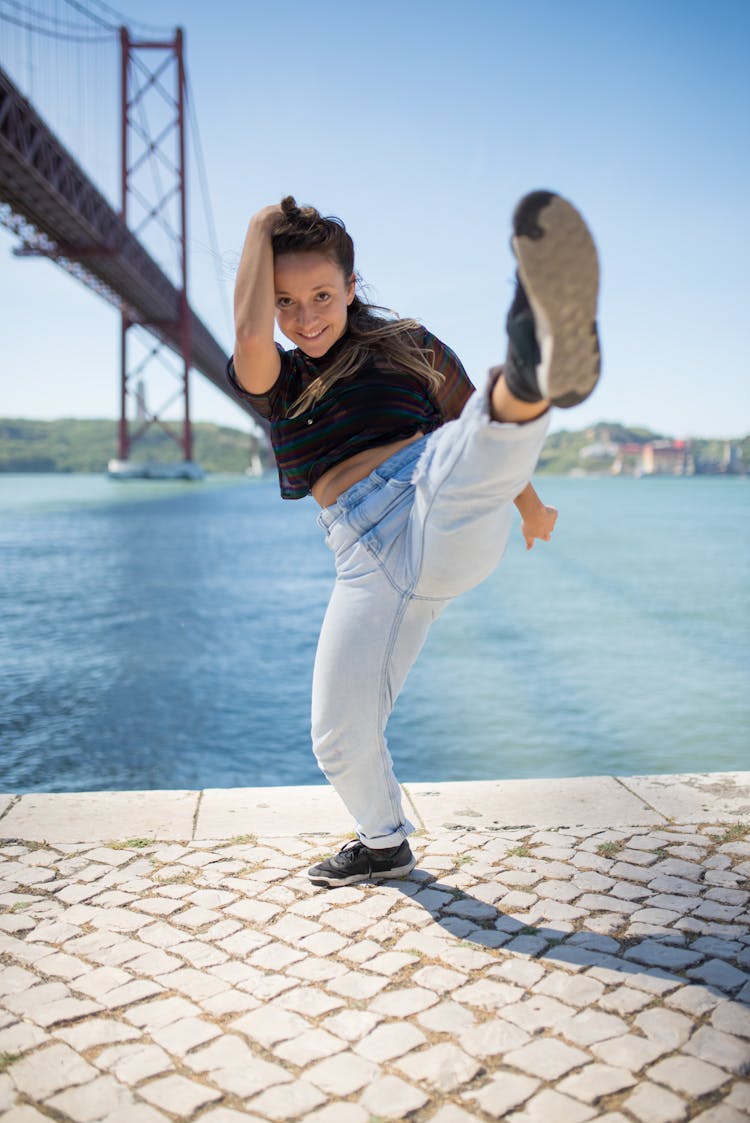 Woman In Black Shirt And Denim Pants Kicking