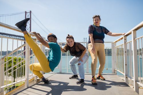 Free Three friends express joy and style in a dynamic pose on the Lisbon Bridge. Stock Photo