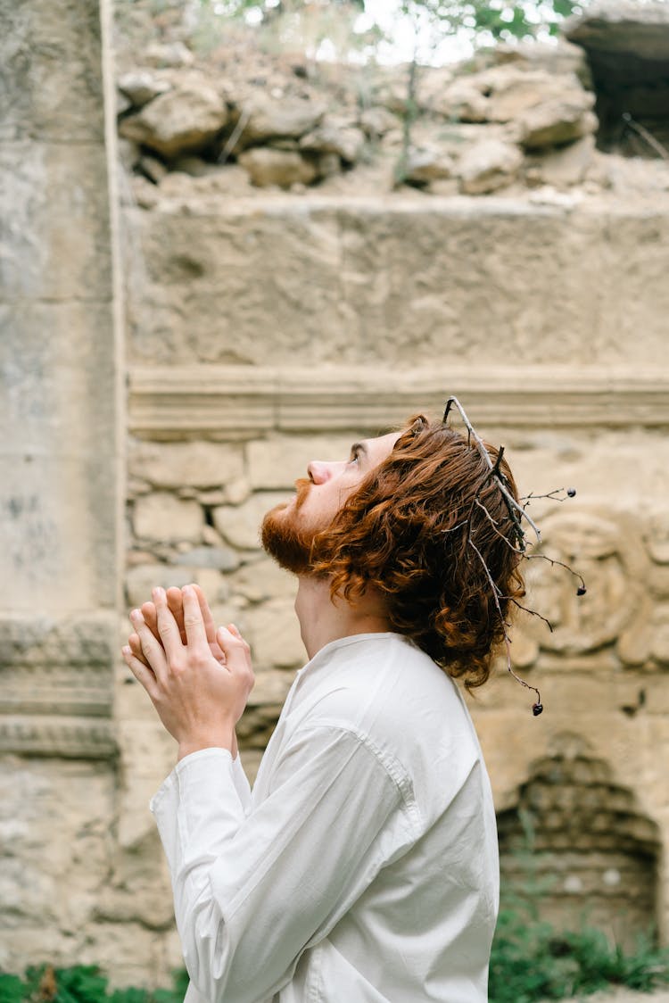 A Bearded Man In White Long Sleeves Praying