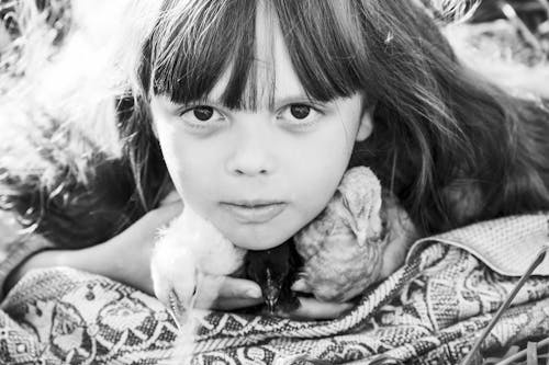 Grayscale Photo of A Pretty Girl Holding Birds