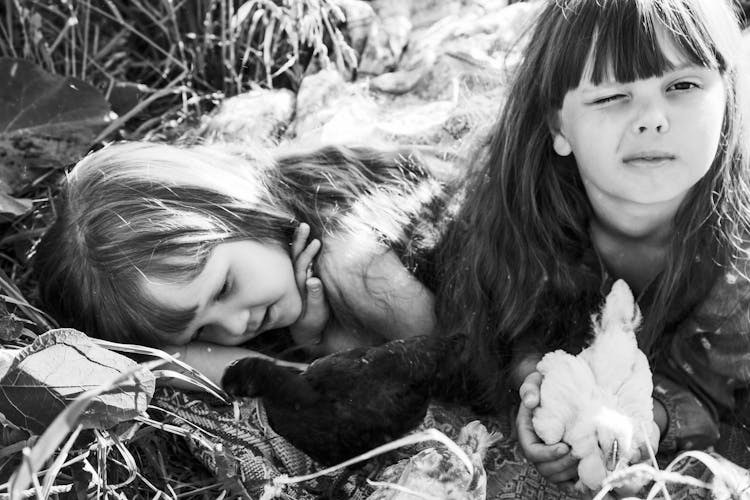 Little Girls Lying On The Ground With Chicks 