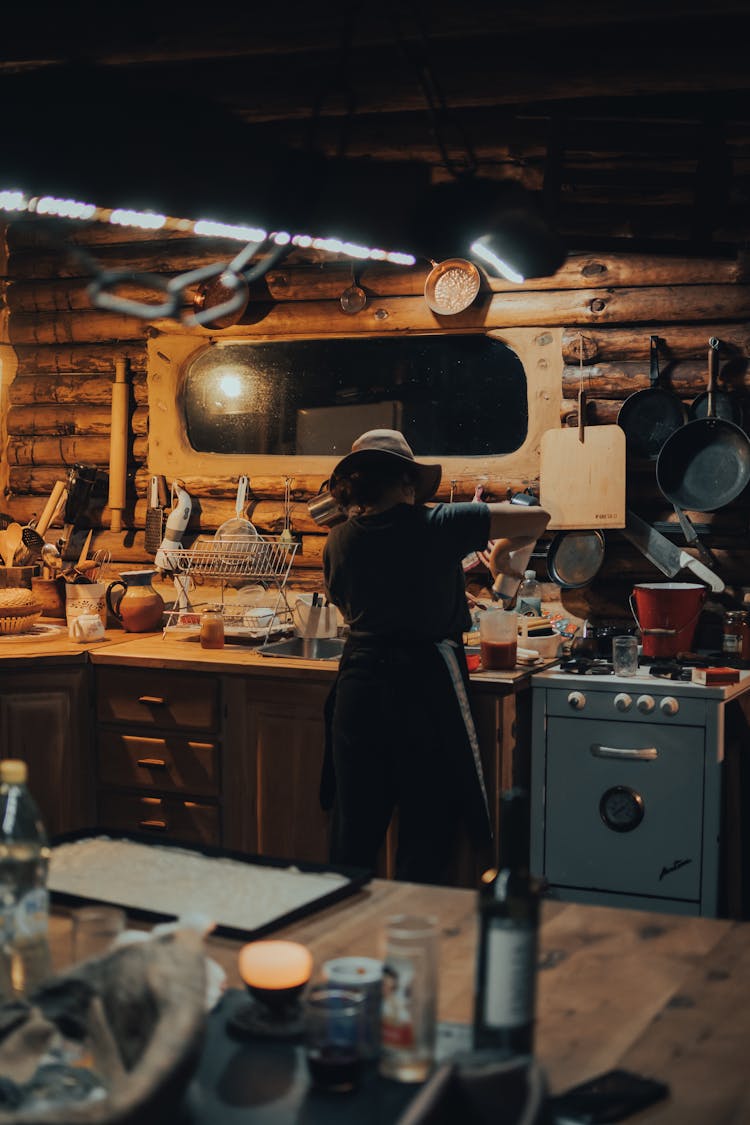 A Woman With A Hat Preparing Food In The Kitchen