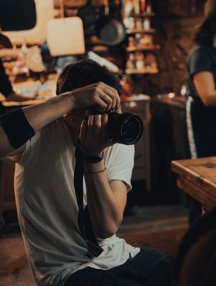 Man With Professional Camera Taking Pictures Indoors