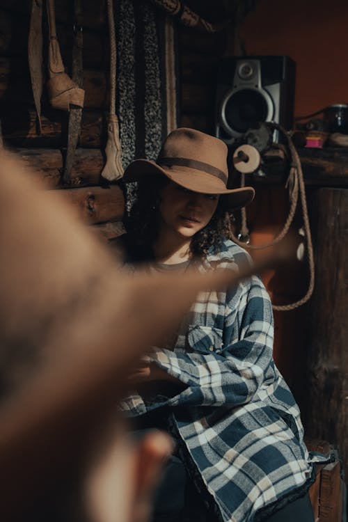 

A Woman in a Plaid Shirt and a Hat