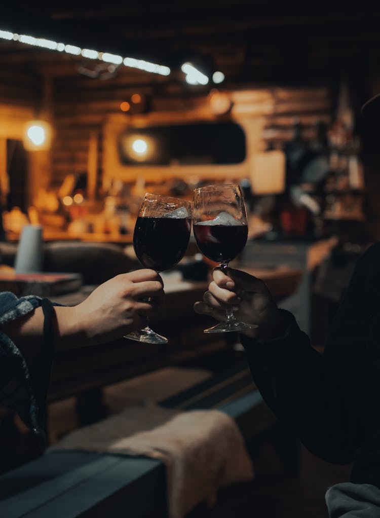 A Couple Toasting Their Glasses Of Wine