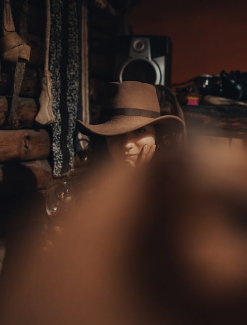 Woman in a Cowboy Hat Sitting in a Room 