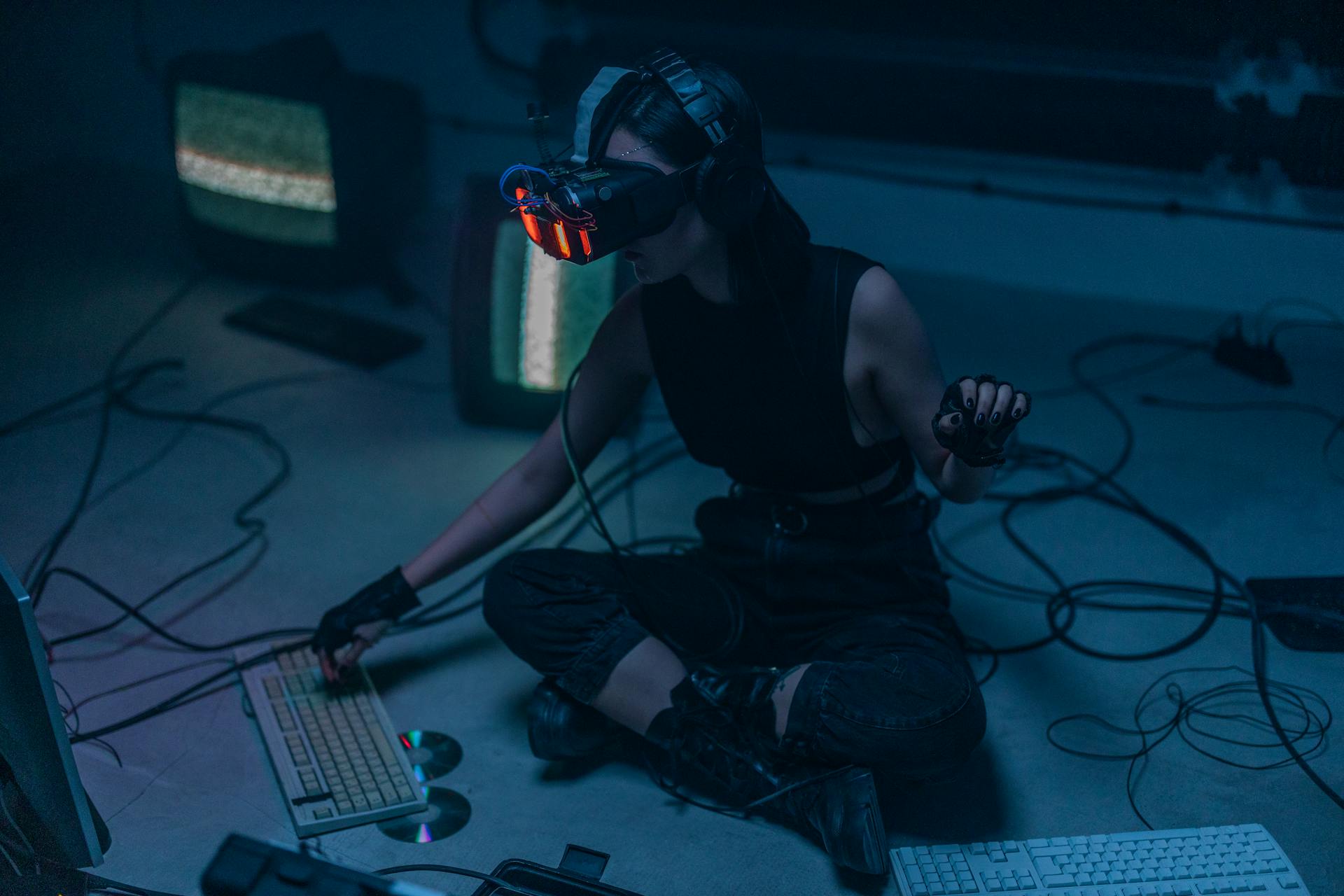 A Woman in a Tank Top Wearing a VR Headset while Typing on a Keyboard