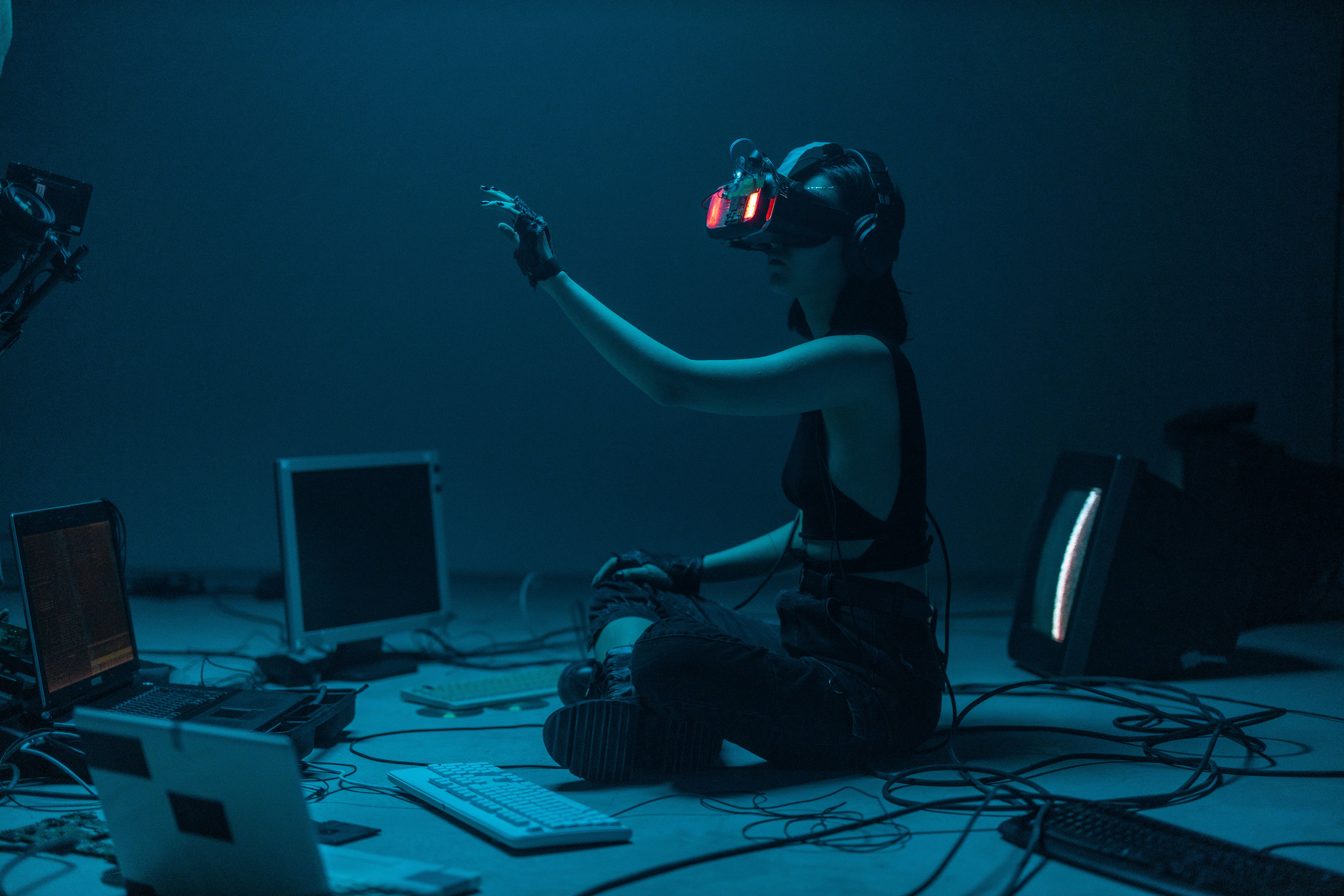 A person using a VR headset and multiple computer screens, symbolizing data science, artificial intelligence, and advanced analytics driving innovation in Kuwait.