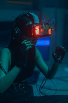 A woman immersed in a virtual reality experience with VR headset in a dimly lit room.