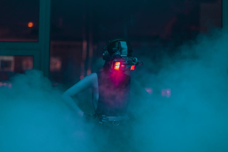 A Woman In A Tank Top Wearing A VR Headset In A Smokey Room